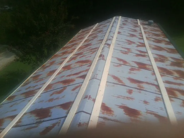 Rusted metal roof panels with new wood purlins before replacement — Storm Damage Roof Repair in Browning by Roofing Brothers