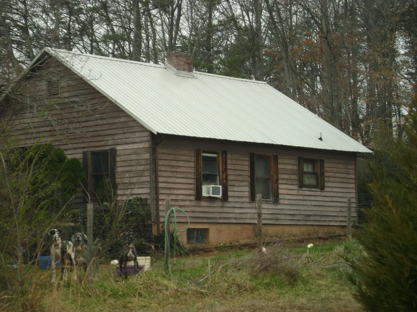 White metal roof on an old wood sided farmhouse, from a Metal Roof Installation job in Browning